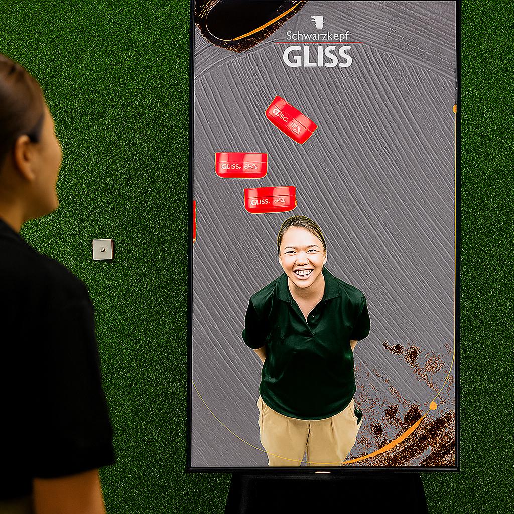 Guest playing interactive balance game using motion sensors to stack virtual items on head at a corporate event or exhibition booth in Dubai – fun and engaging activity.